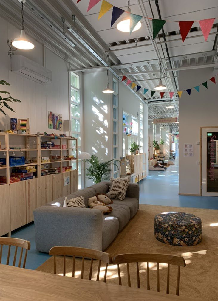 Interior of the We House Meltsi community house in Helsinki with bunting, toys and a reading corner